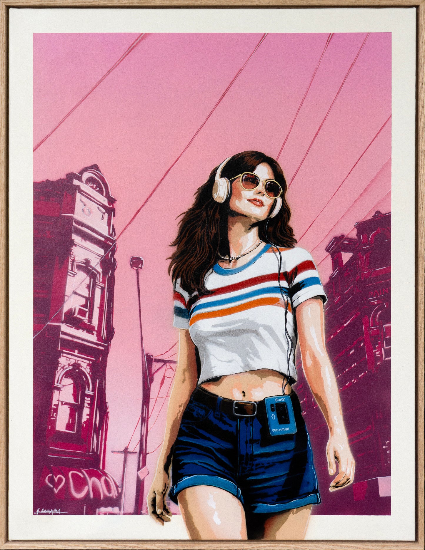 Framed artwork of a cool young, confident woman with headphones against a pink cityscape background